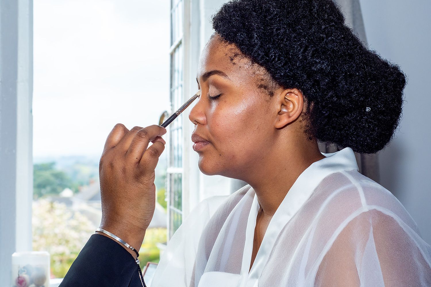 Getting ready shots showing wedding day makeup application and preparations.