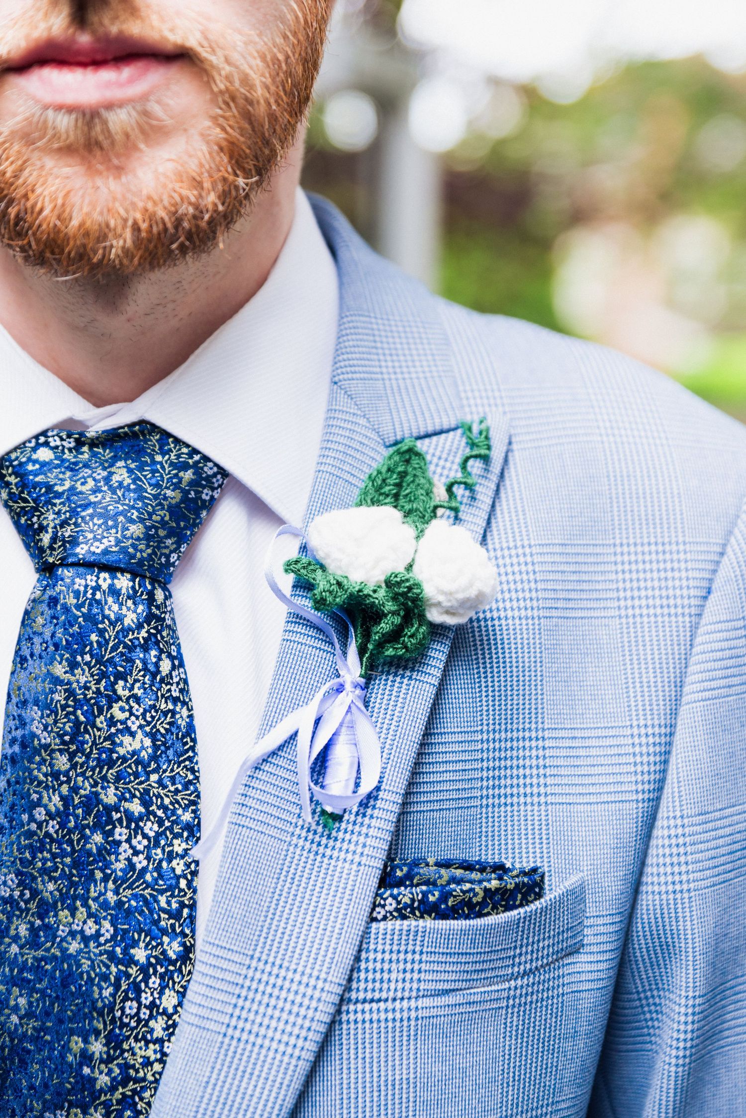 Light blue suit jackets with navy floral ties and white boutonnieres create an elegant groomsmen look.