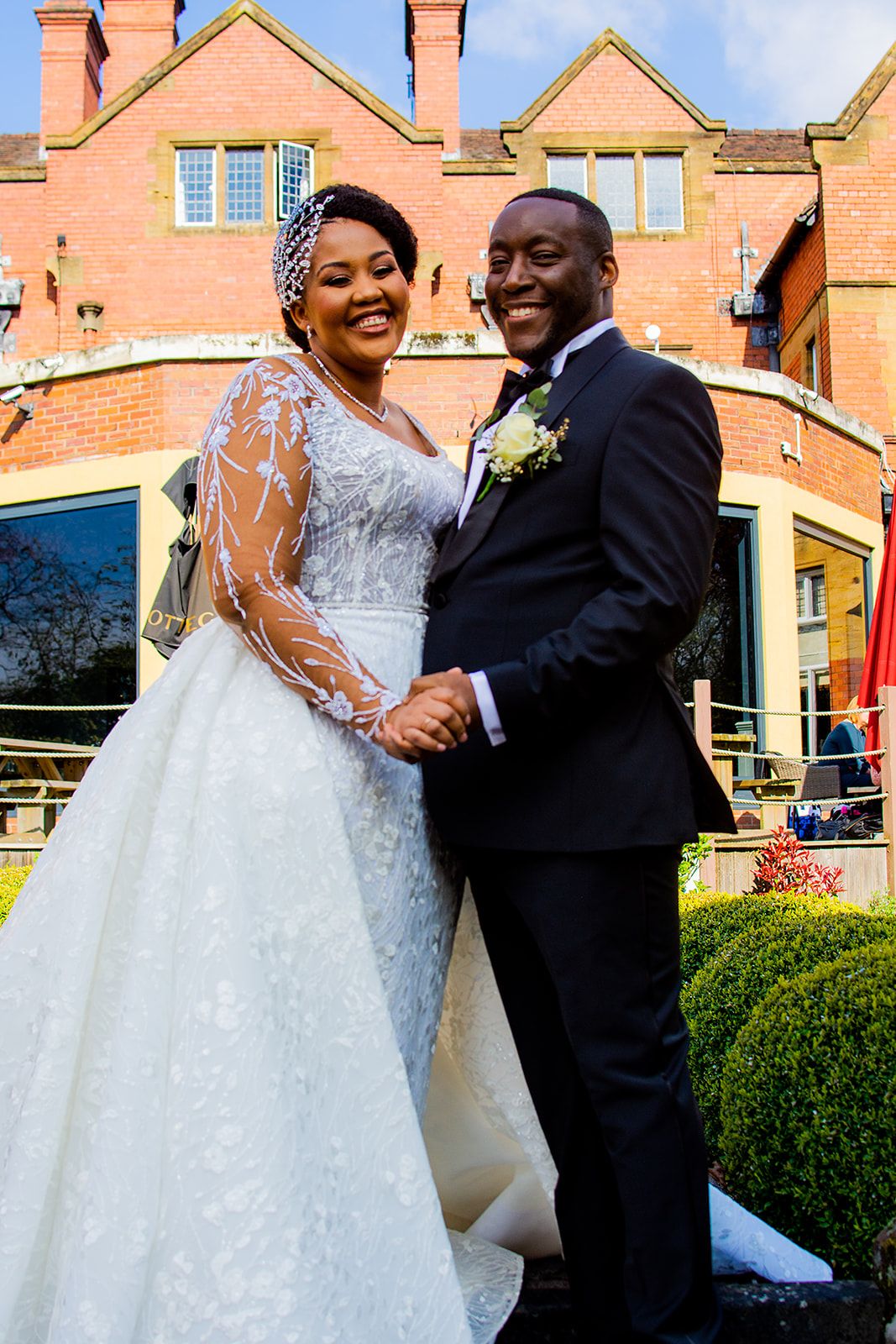 A couple shares a romantic dance moment outside a brick building on their wedding day.