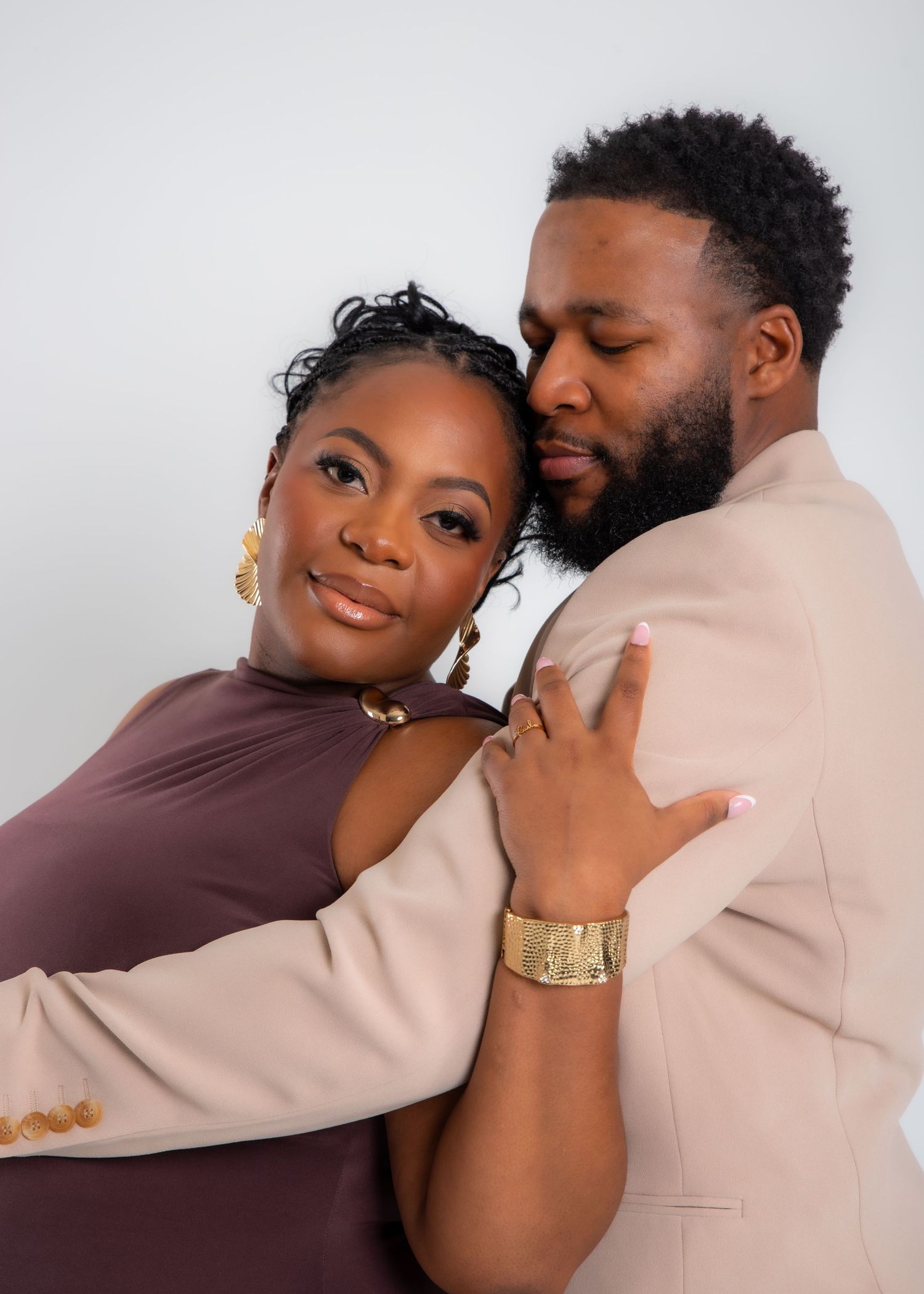A romantic couple in matching brown and beige outfits embraces tenderly in a series of intimate portrait photos.