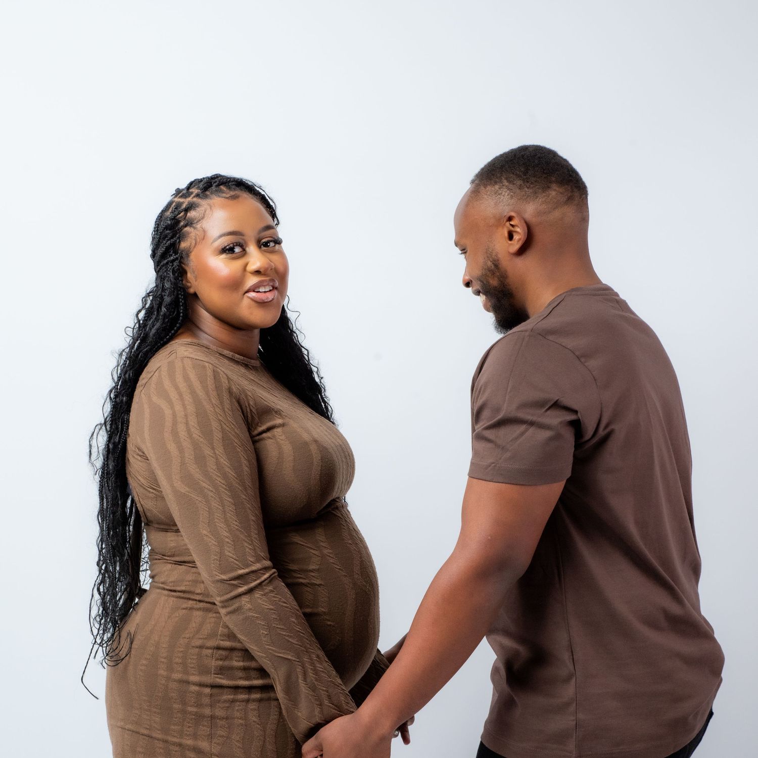 A couple in matching brown outfits shares intimate moments in a series of romantic poses against a light background.