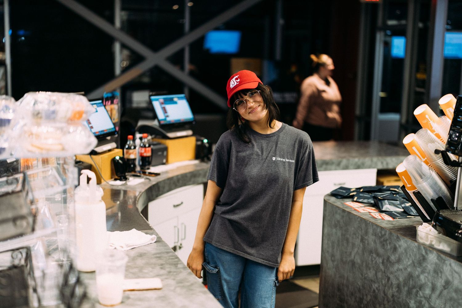 Kitchen staff preparing food and drinks at a busy service counter.