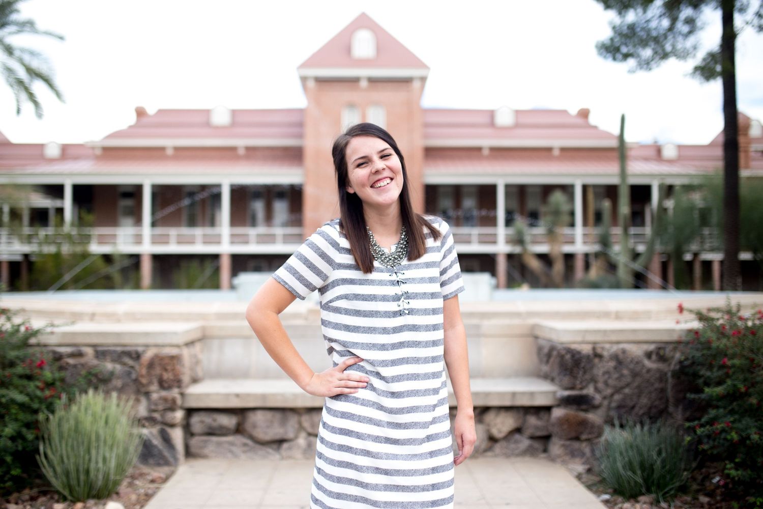 Striped shirt against pink building architecture in outdoor setting.