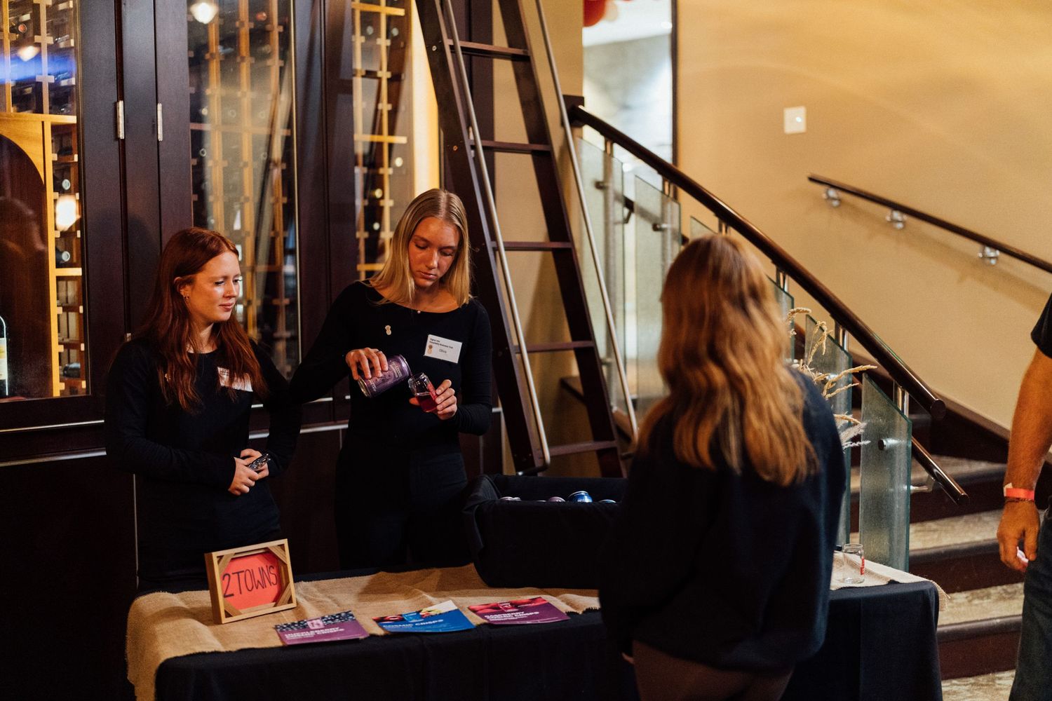 People gathered at tables during an indoor networking or social event.