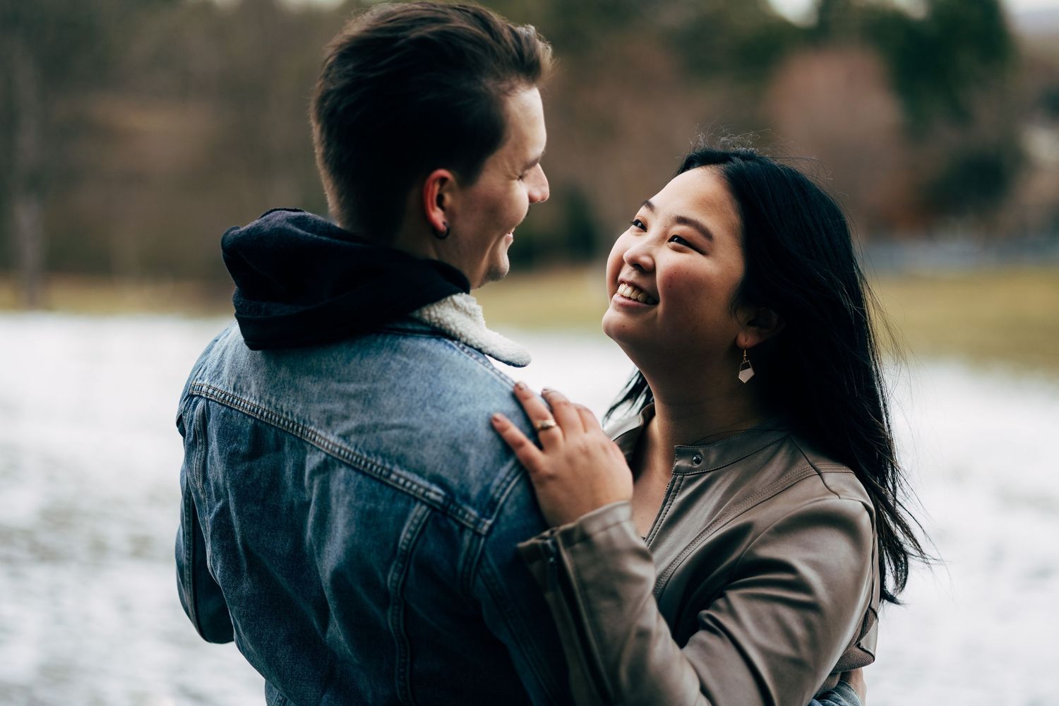 A couple embraces and laughs together during an outdoor photoshoot.