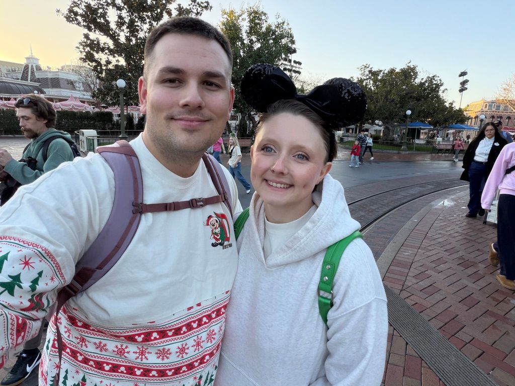 A couple wearing matching winter sweaters with Nordic patterns at a holiday event.