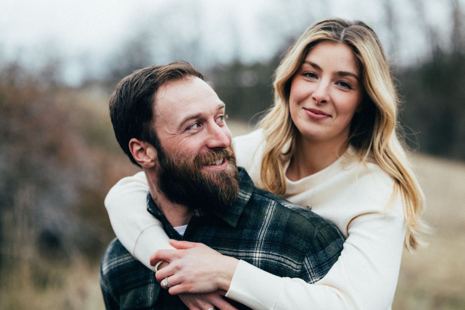A playful embrace between a couple wearing coordinating winter outfits.
