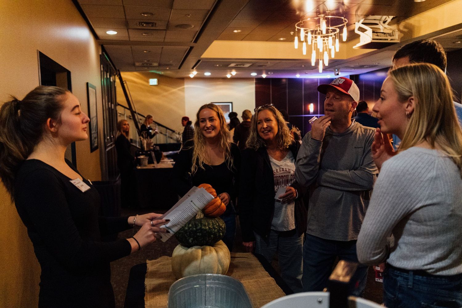 People mingling at an indoor social gathering with warm lighting.