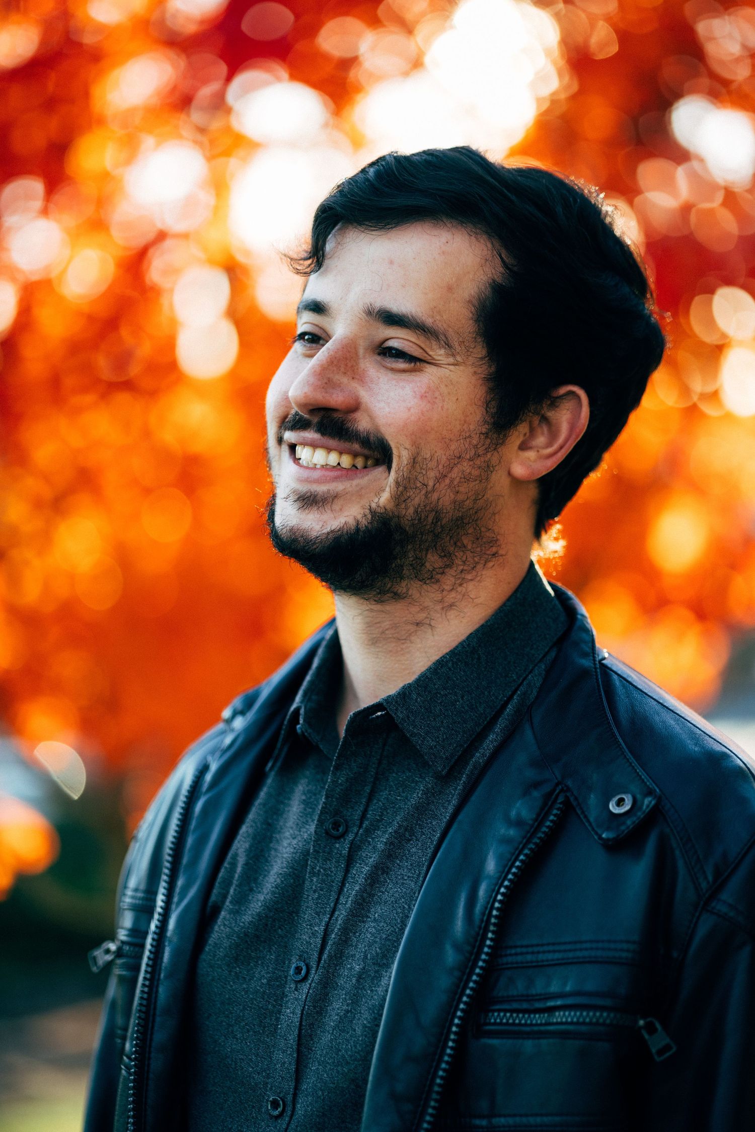 Candid portraits with warm autumn bokeh lighting and black jacket.