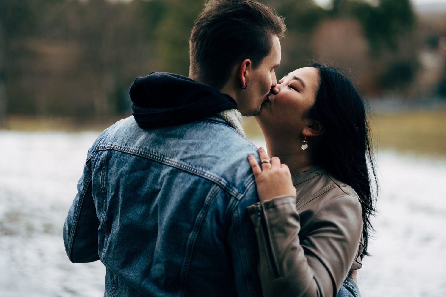A romantic winter scene with a couple sharing a tender moment in the snow.