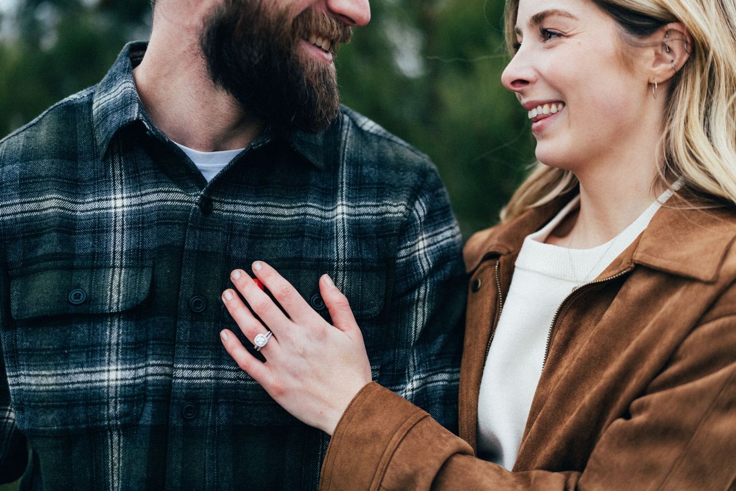 A close-up shot of a couple sharing a lighthearted moment in outdoor winter clothing.