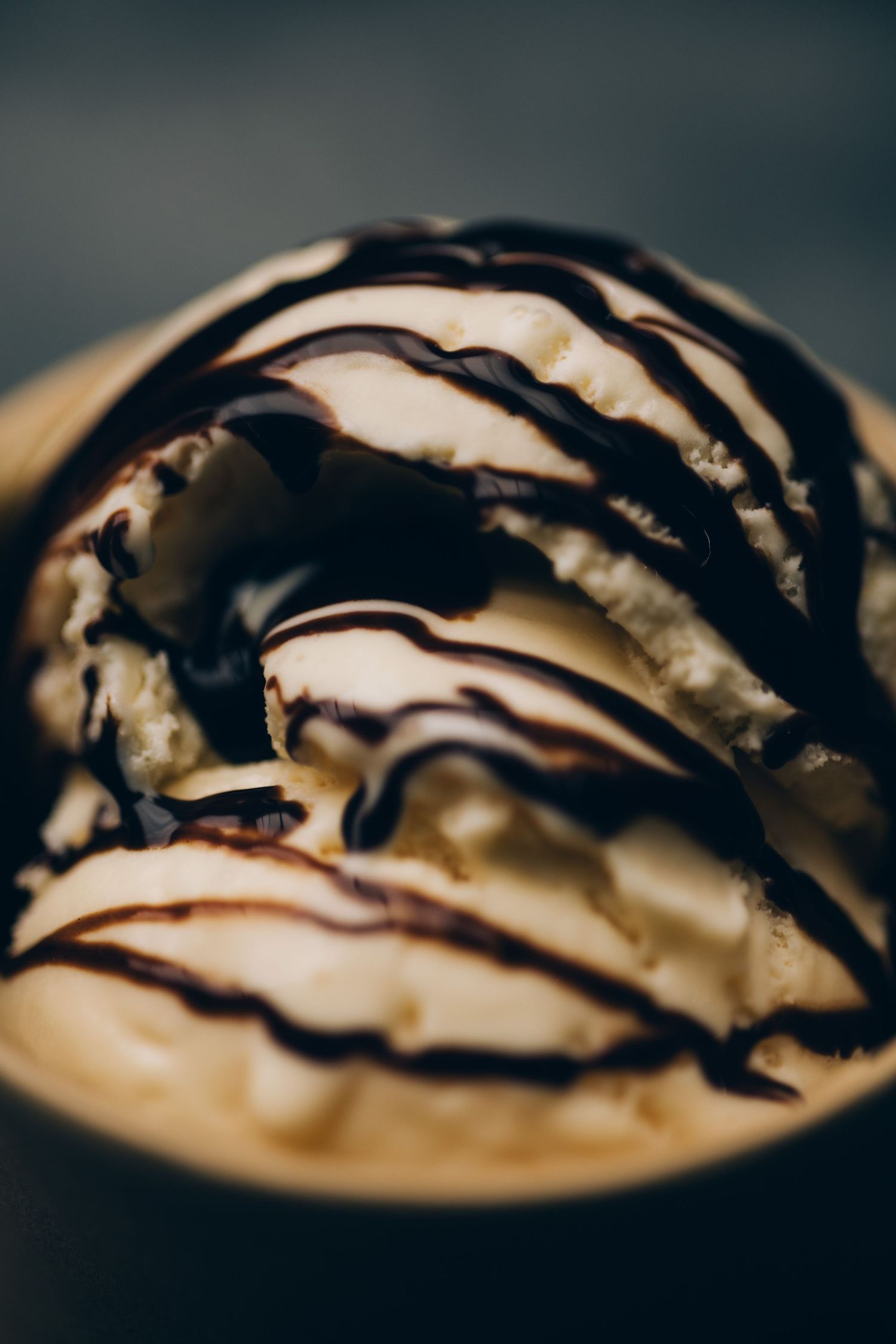 Close-up of chocolate drizzle pattern on whipped cream dessert.