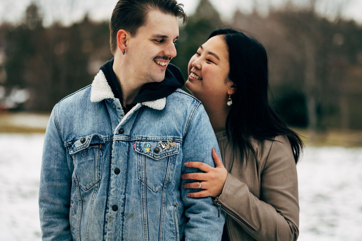 Couple sharing intimate moment outdoors in winter clothing.