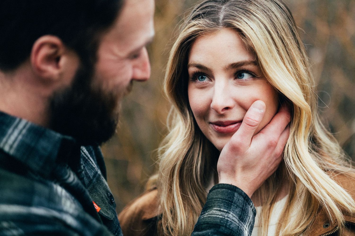 A tender moment captured between a couple as they share an intimate gaze outdoors.