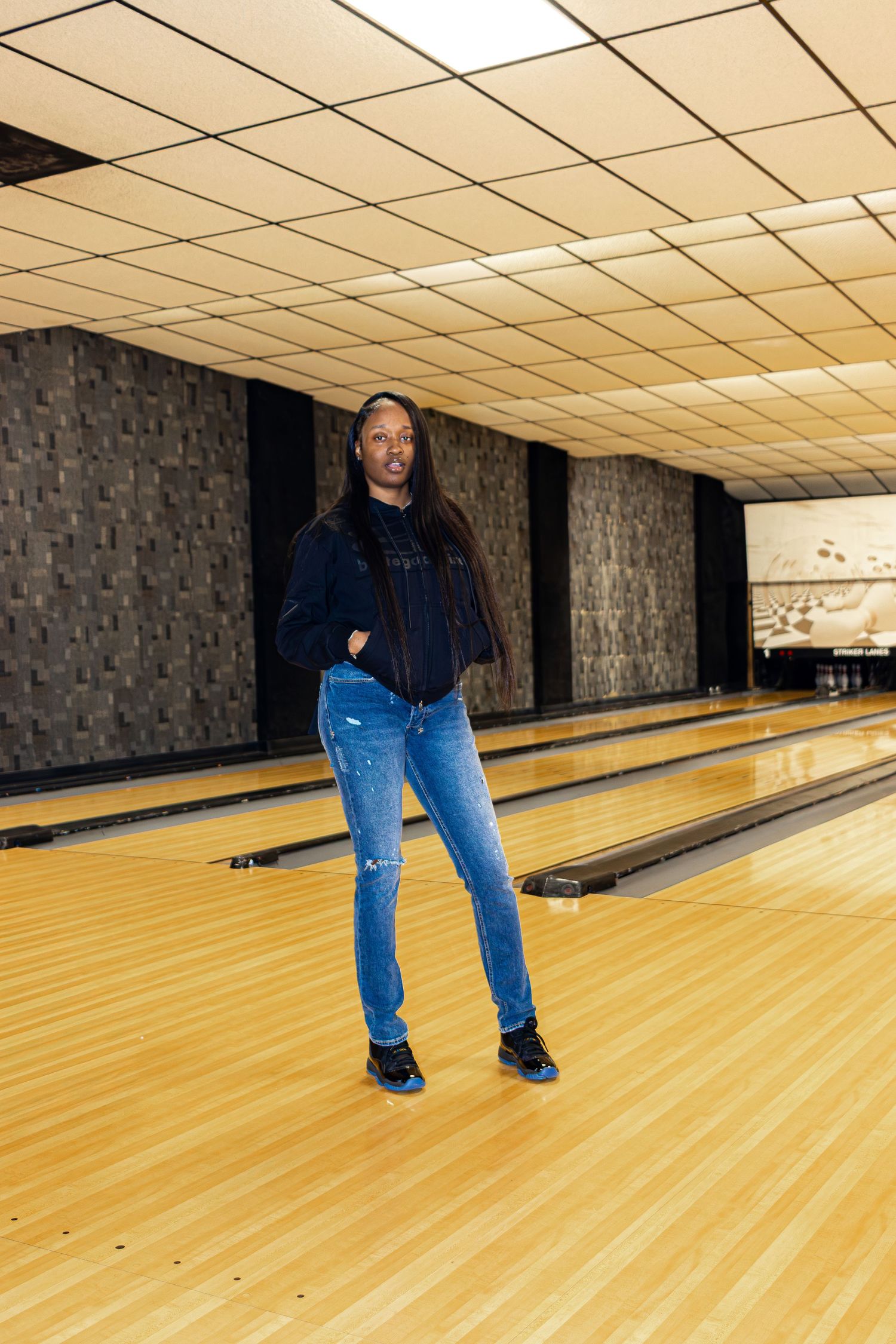A sequence of bowling lane shots showing someone preparing to bowl in a dimly lit bowling alley.