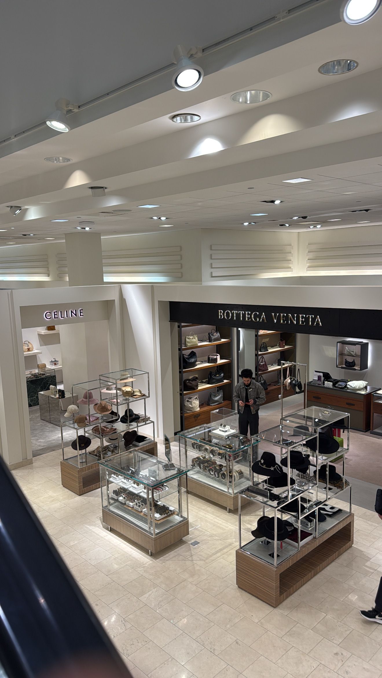 Luxury retail display cases featuring Celine and Bottega Veneta brands in an upscale department store setting.