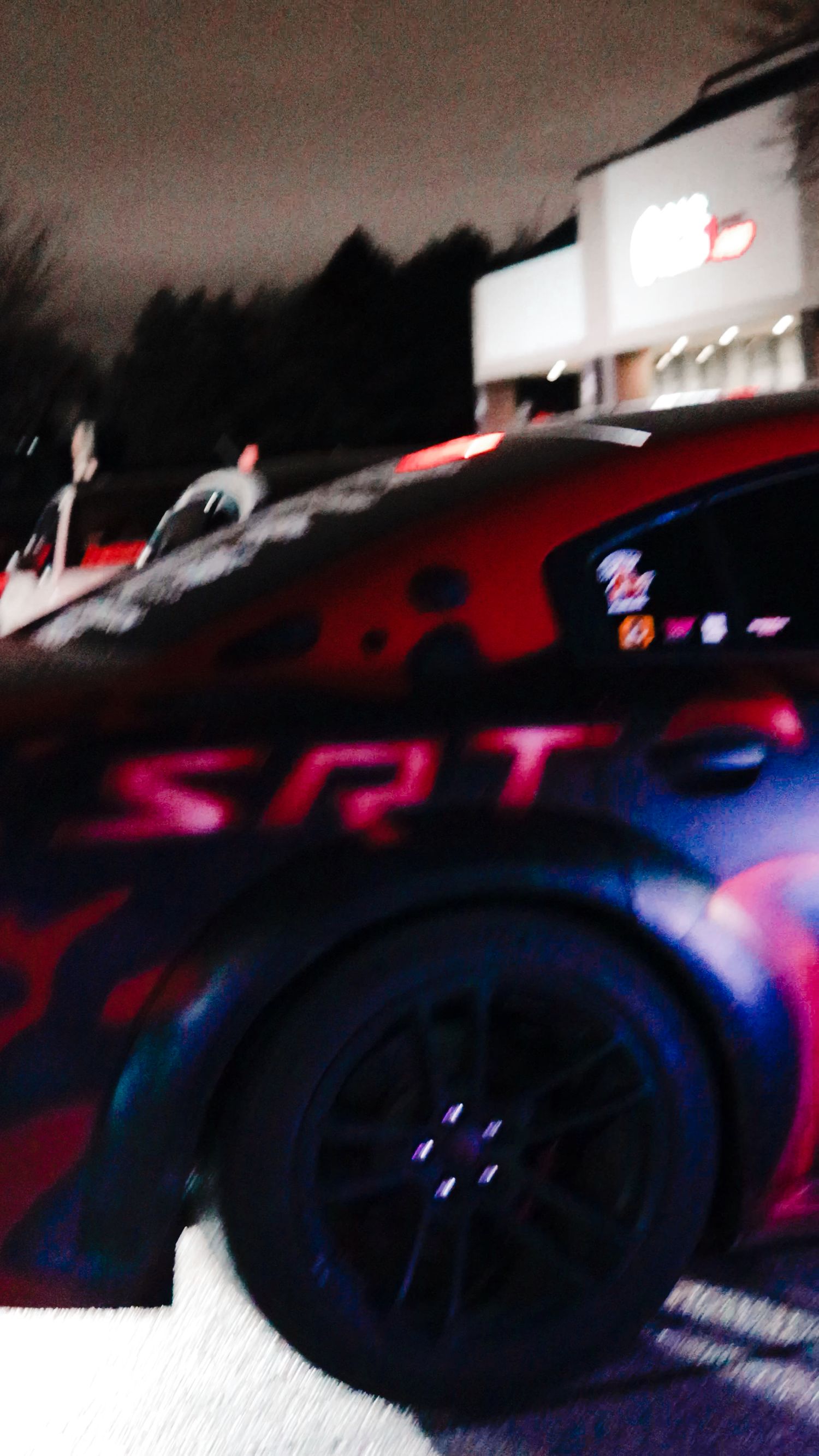Blurred nighttime shot of cars with red and blue lighting effects.