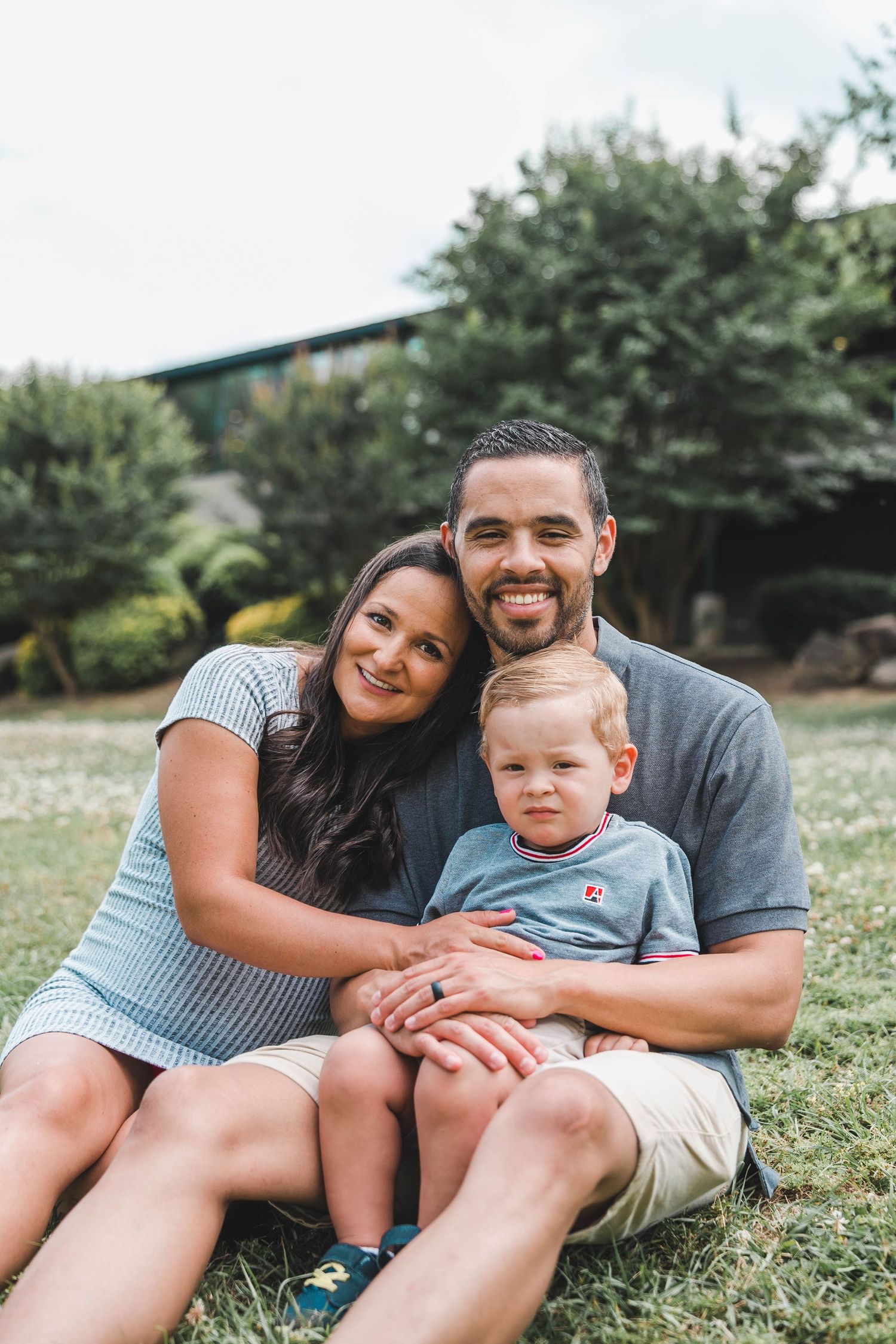 Family laying together on grass during outdoor portrait session.