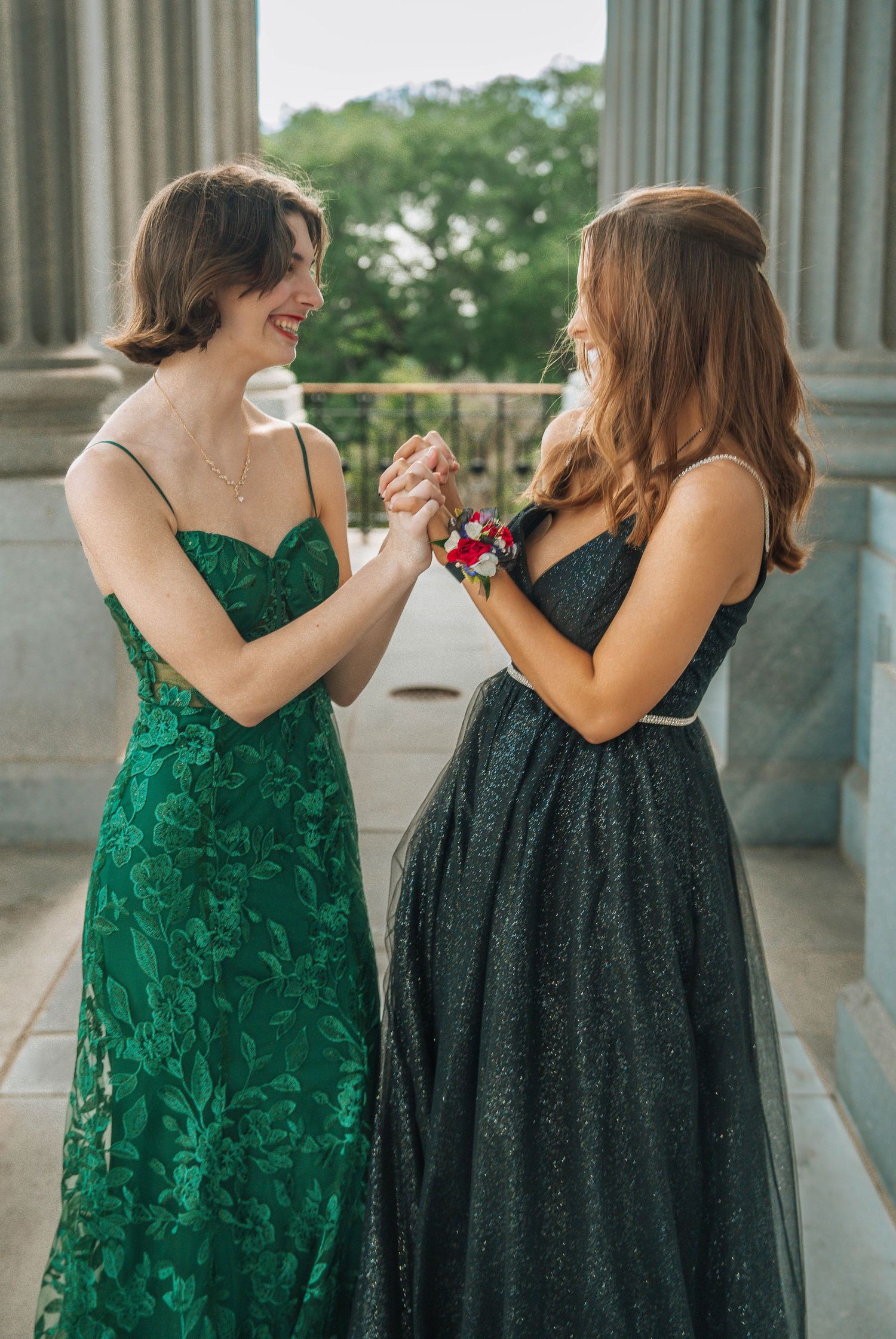 Two formal dresses shown side by side - one emerald green lace and one black sparkly gown.