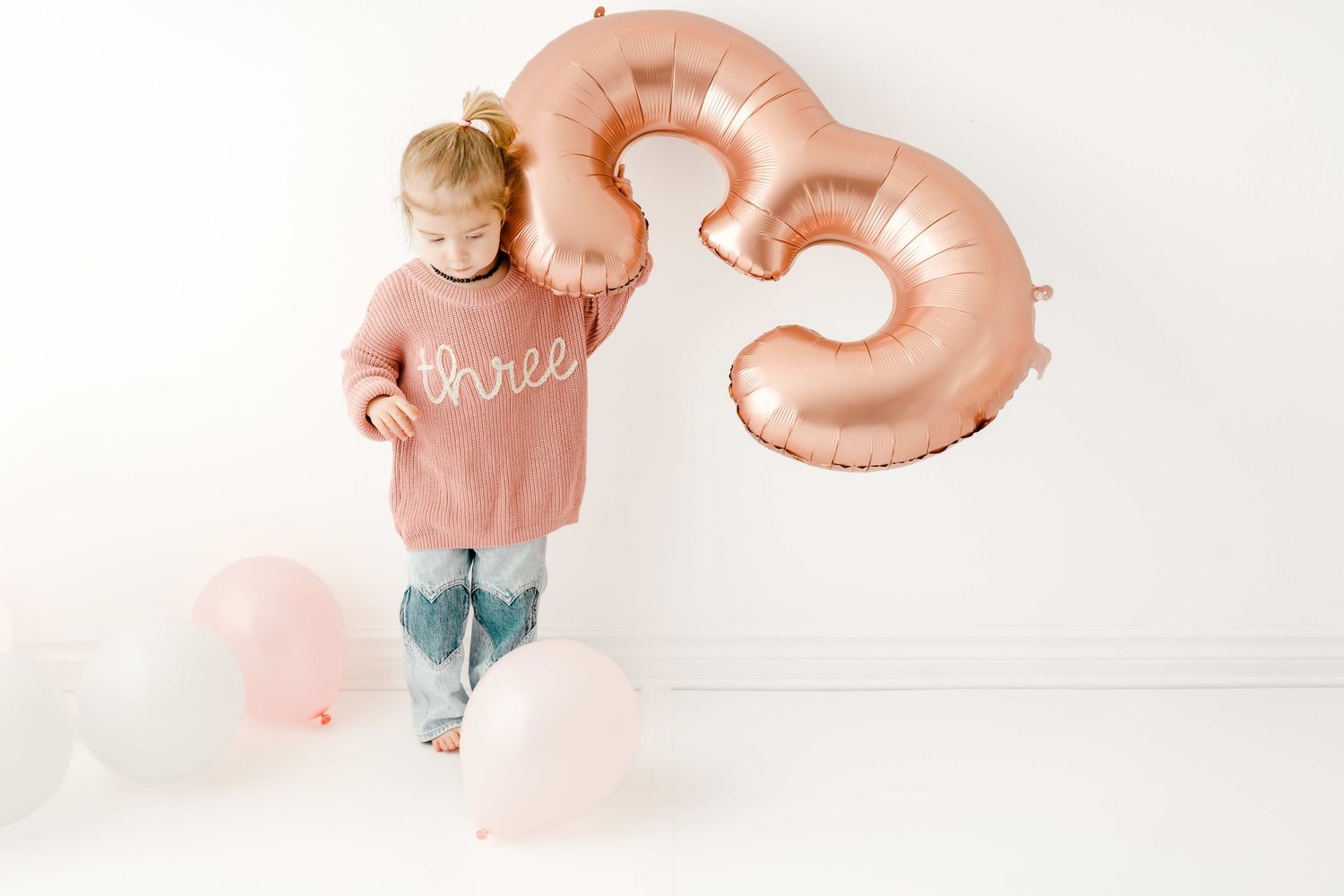 A sequence of images showing a pink heart-shaped balloon floating and moving against a white background.
