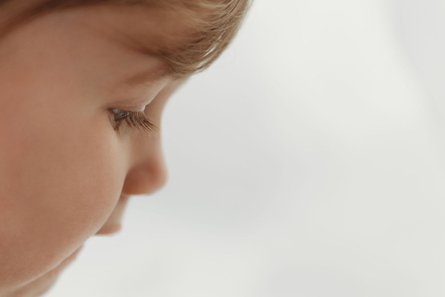 Close up macro shot showing the profile of a baby's face with soft lighting and shallow depth of field.