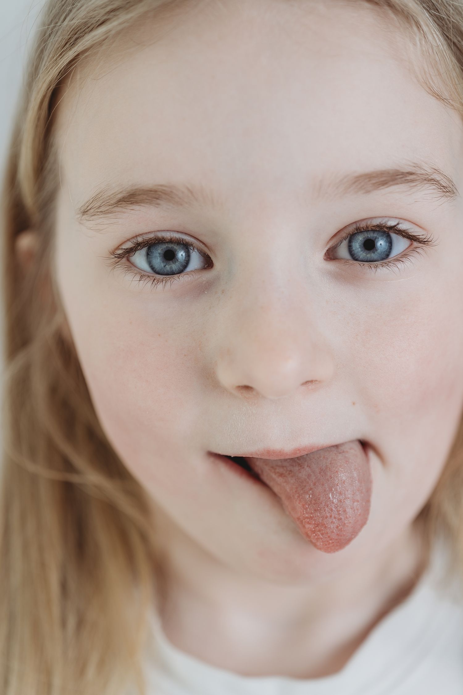 A series of close-up shots showing a child sticking out their tongue playfully in different expressions.