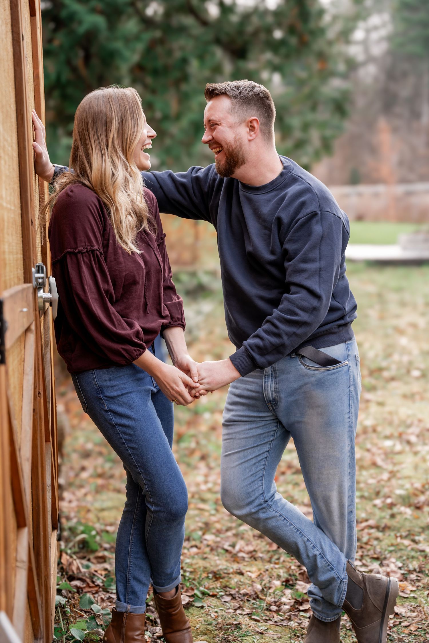 Couple in casual fall outfits playfully interacting in a series of romantic photos taken outdoors among autumn leaves.