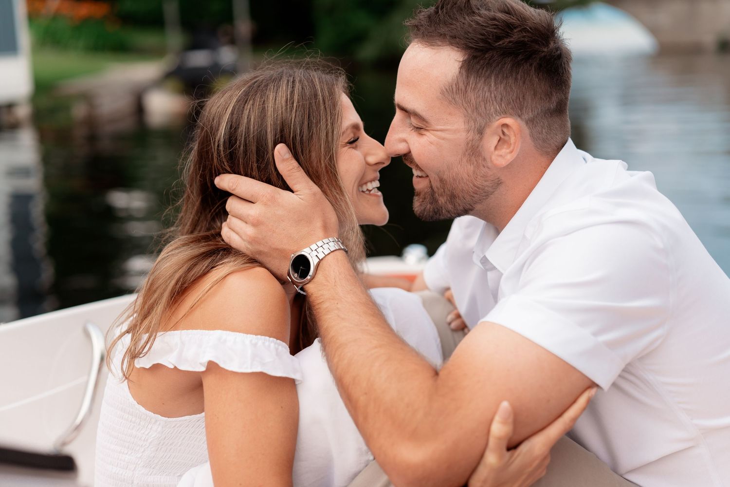 A couple in white outfits share romantic moments in a series of intimate photos by the water.