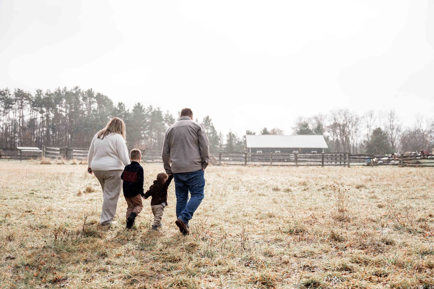 A group of people walking together through a misty field on a winter morning.