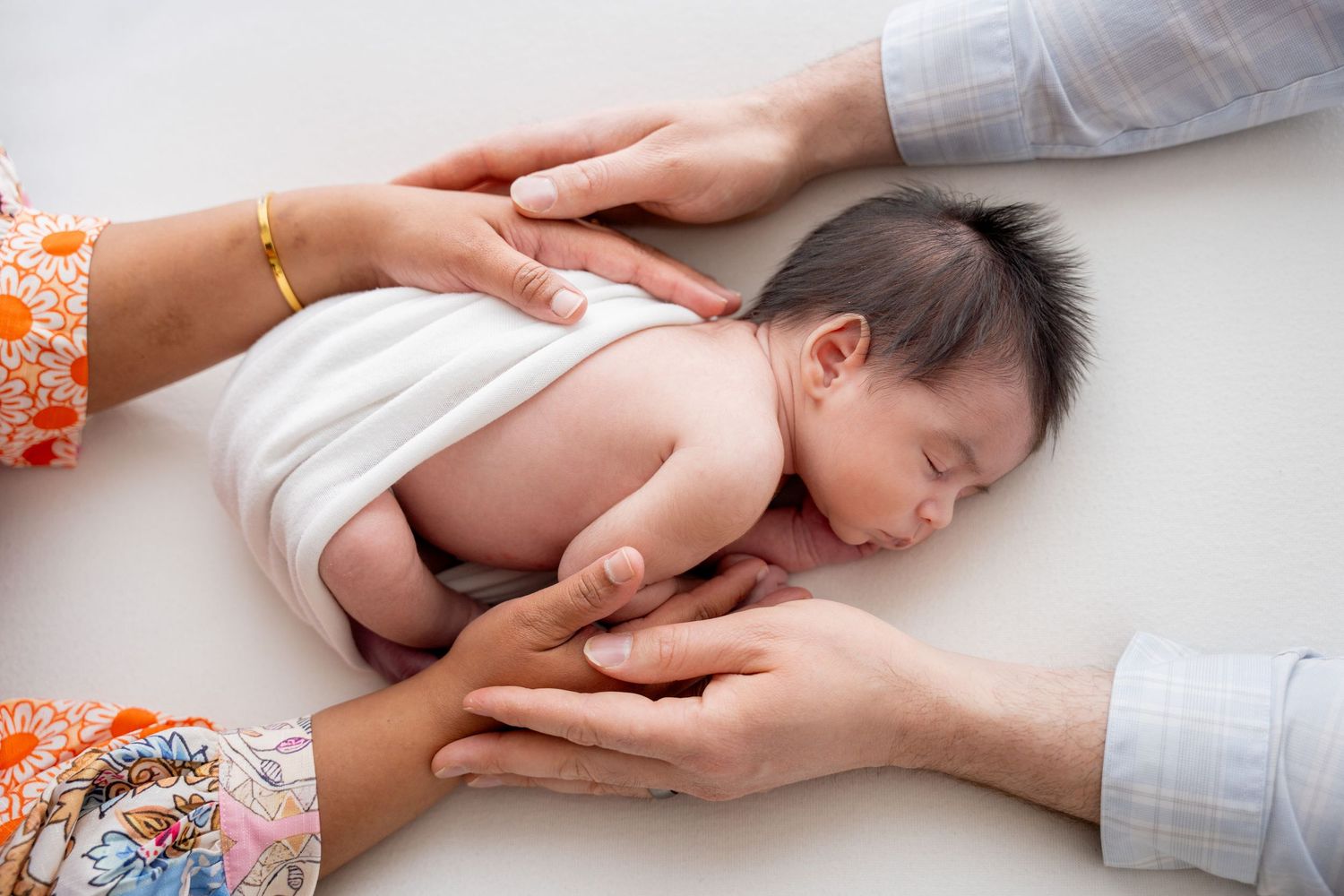 A sequence of hands performing a therapeutic massage on a person lying down on a white surface.