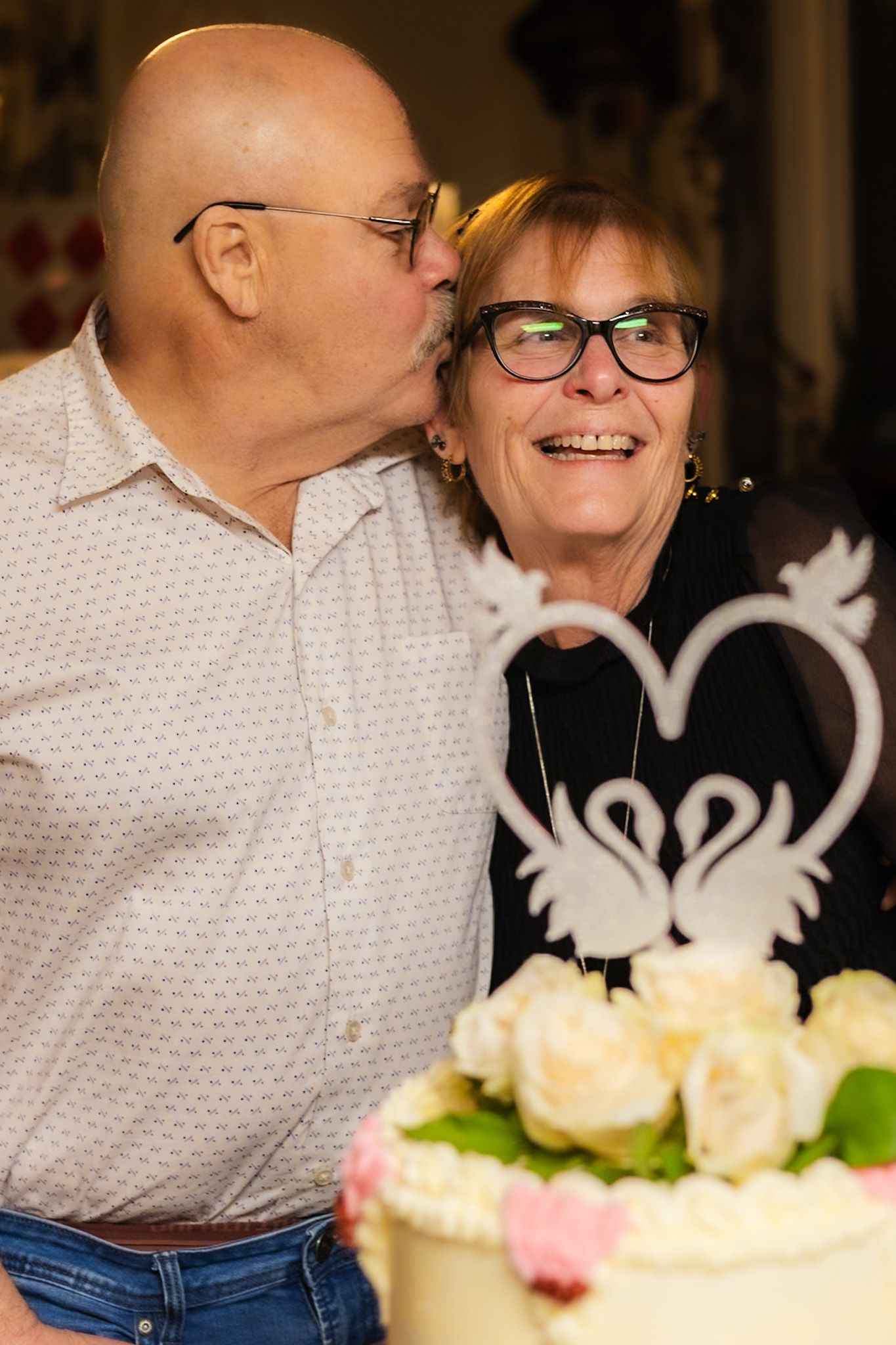 A sweet anniversary kiss by bob in front of the cake by smc shots
