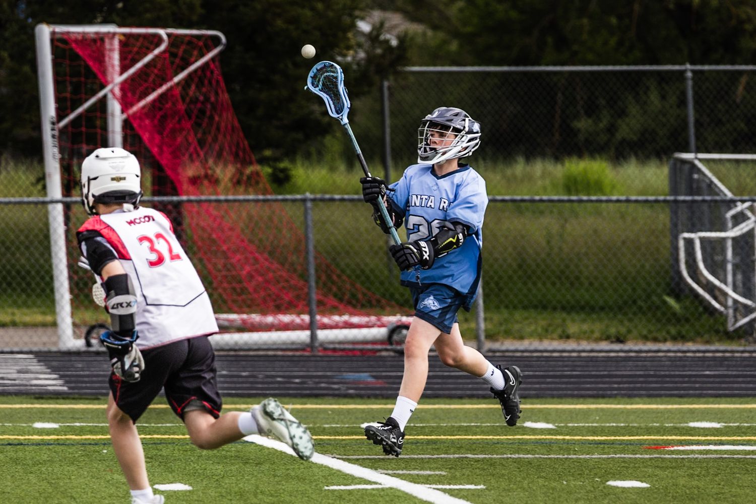 Lacrosse net almost catching ball as runner runs in Montgomery match by Sonoma county photographer smc shots