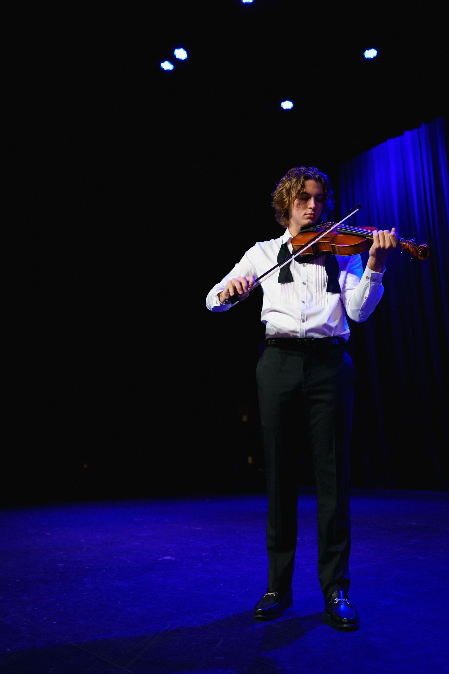 High school senior guy playing violin on stage at The Clayton Center in downtown Clayton, NC