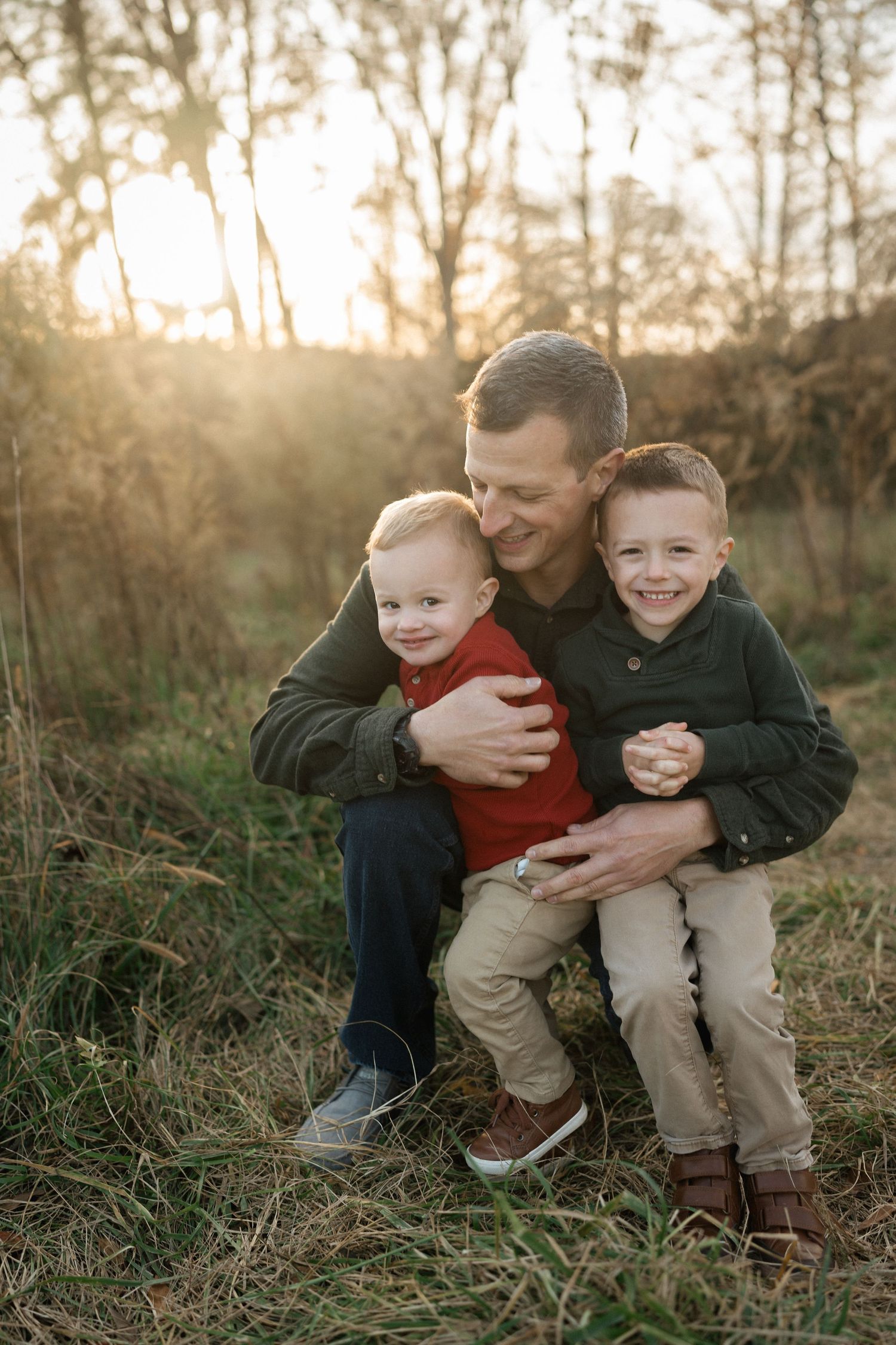 Young child smiling while being held by a parent during a family photo session at sugg farm