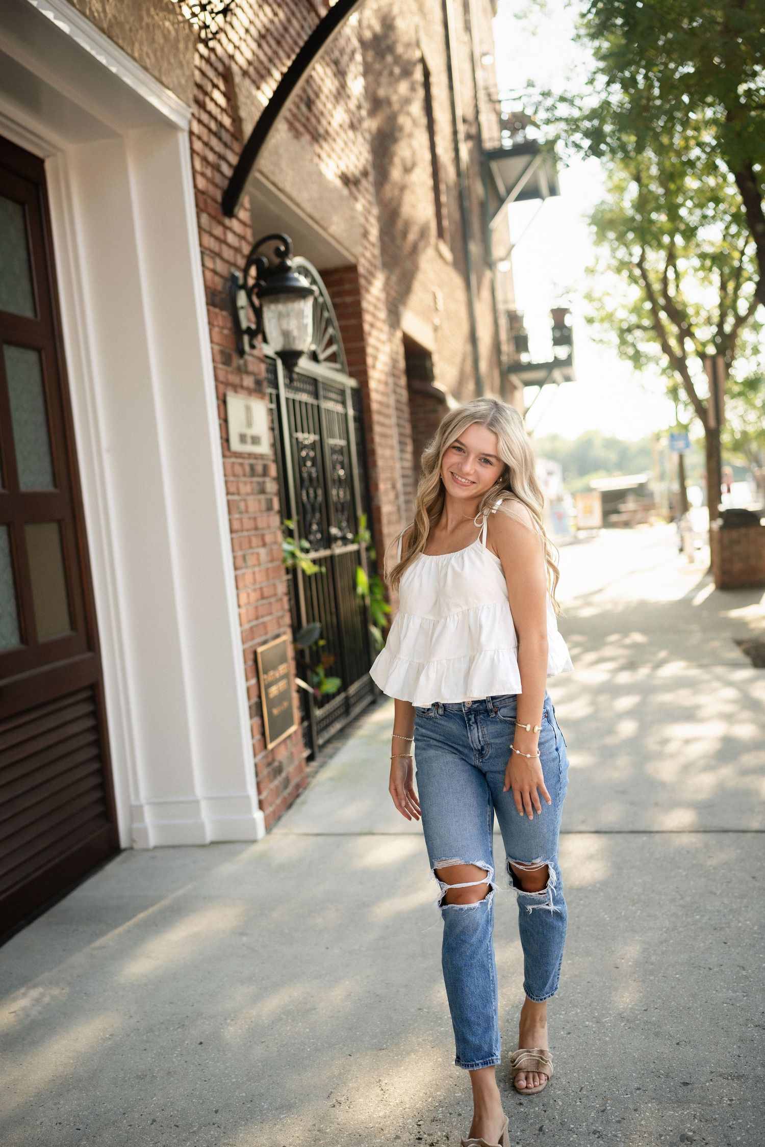 Sydney's senior portrait at a gated home entrance in downtown Wilmington, NC, featuring elegant ironwork and greenery