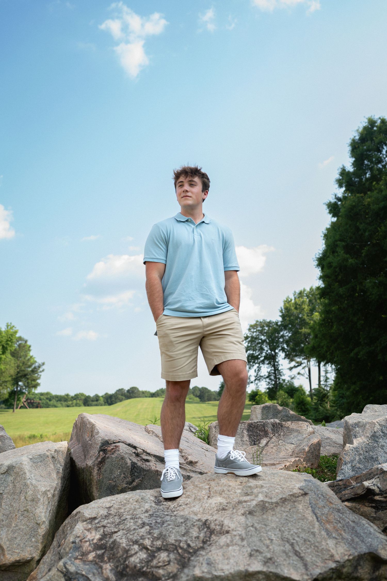 Senior boy portrait on rocks at the North Carolina Museum of Art in Raleigh