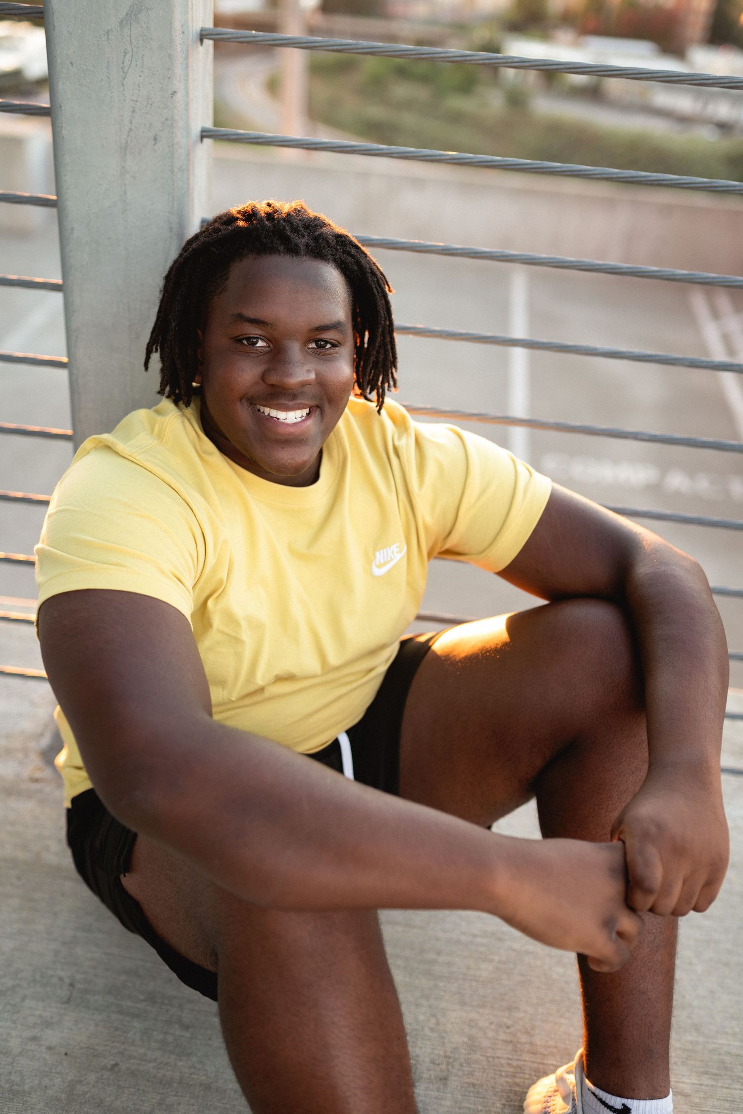 High school senior guy portrait on a rooftop parking deck in downtown Raleigh at golden hour