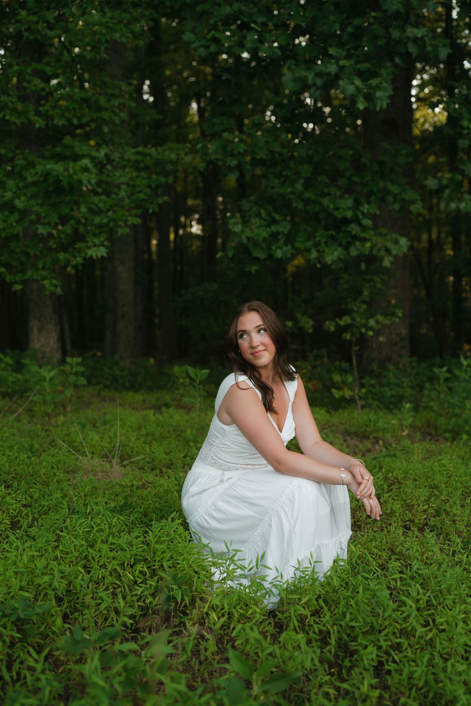 High school senior girl in a grassy field at Wilkerson Nature Preserve during a summer senior portrait session near Raleigh, North Carolina