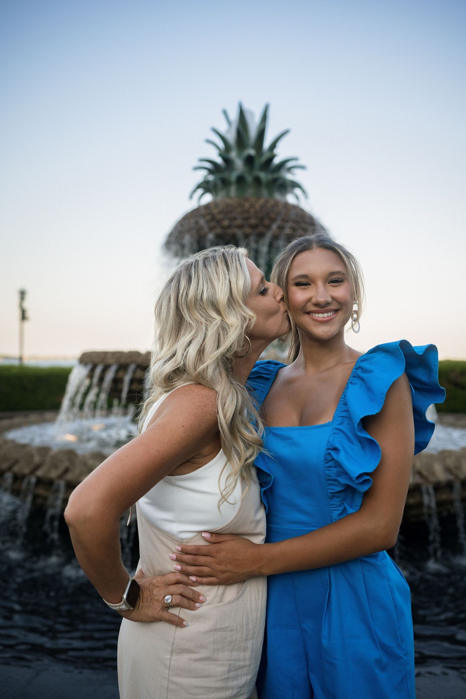 Cardinal Gibbons High School senior smiling near the Pineapple Fountain surrounded by trees – Raleigh NC senior photographer.