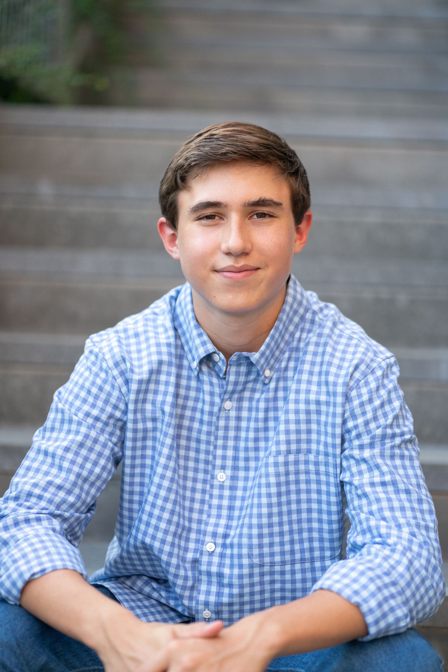 Close-up portrait smiling in a blue checkered shirt at NCMA senior session