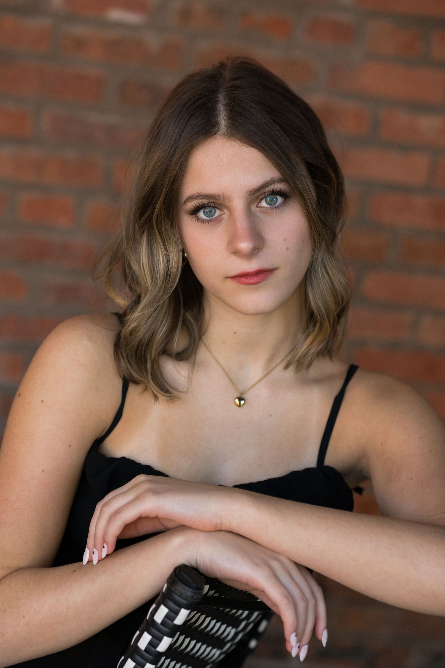 Close-up of a high school senior girl leaning on a chair at American Tobacco Campus in Durham, North Carolina.