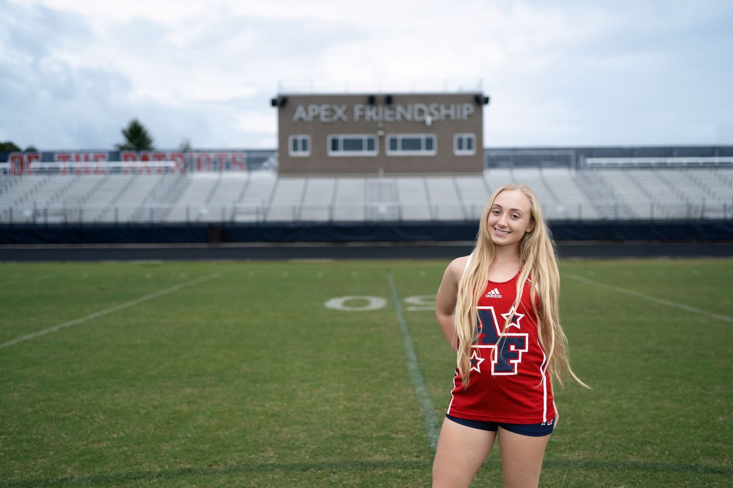 High school senior girl posing on the track at Apex Friendship High School in Apex, North Carolina.