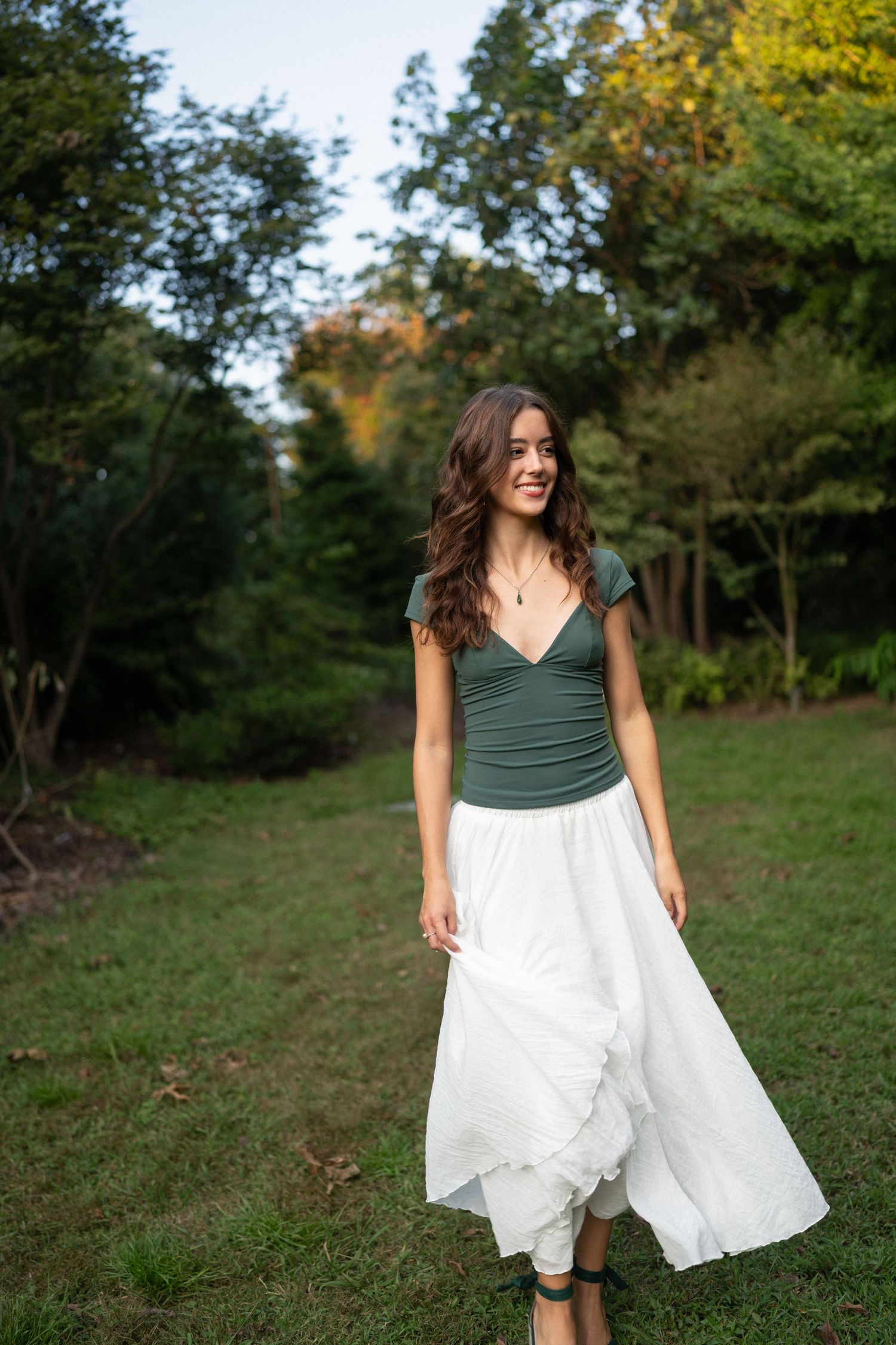 High school senior girl walking during her session at JC Raulston Arboretum in Raleigh, North Carolina.