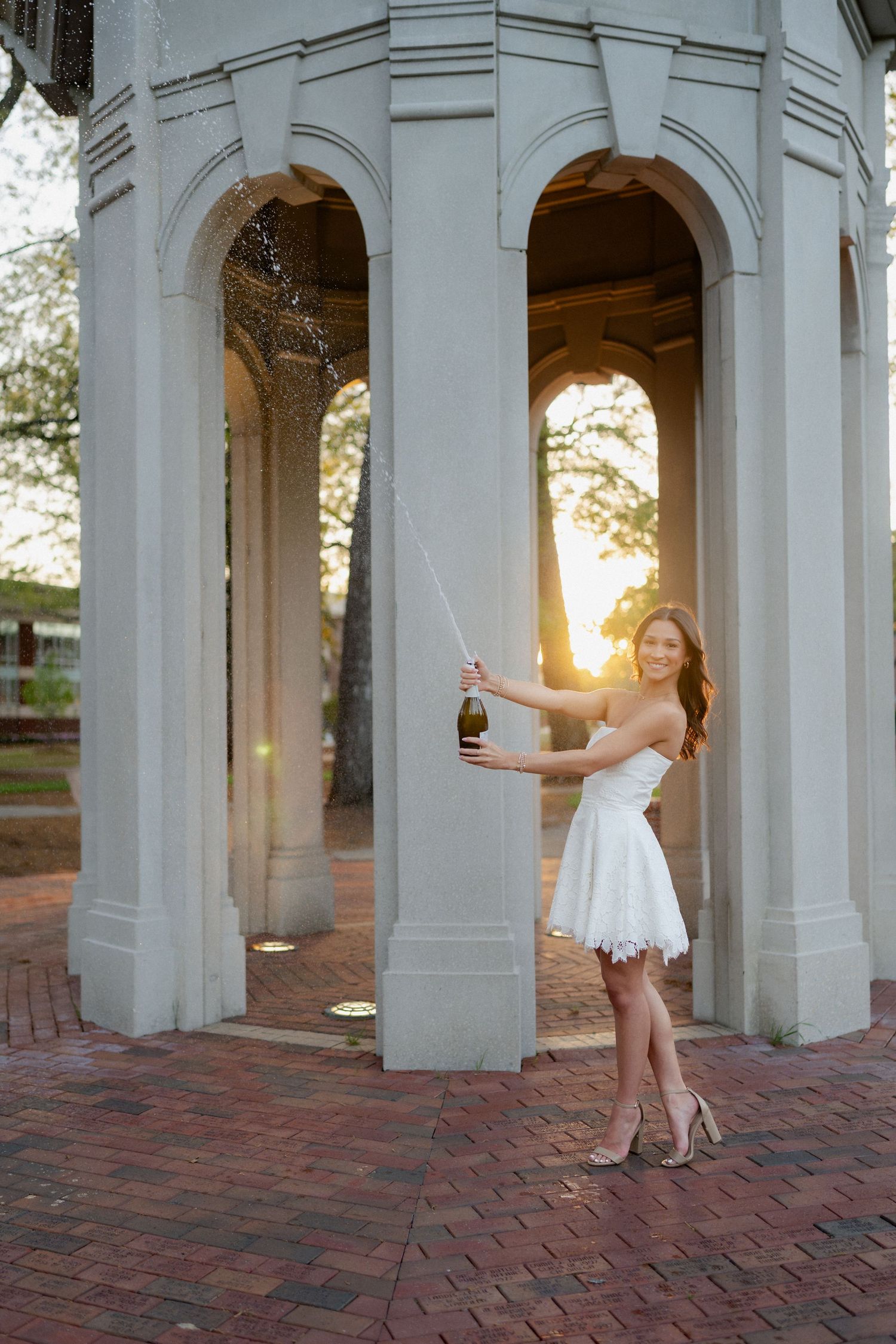 East Carolina University graduate celebrating with champagne at the Cupola in Greenville, NC
