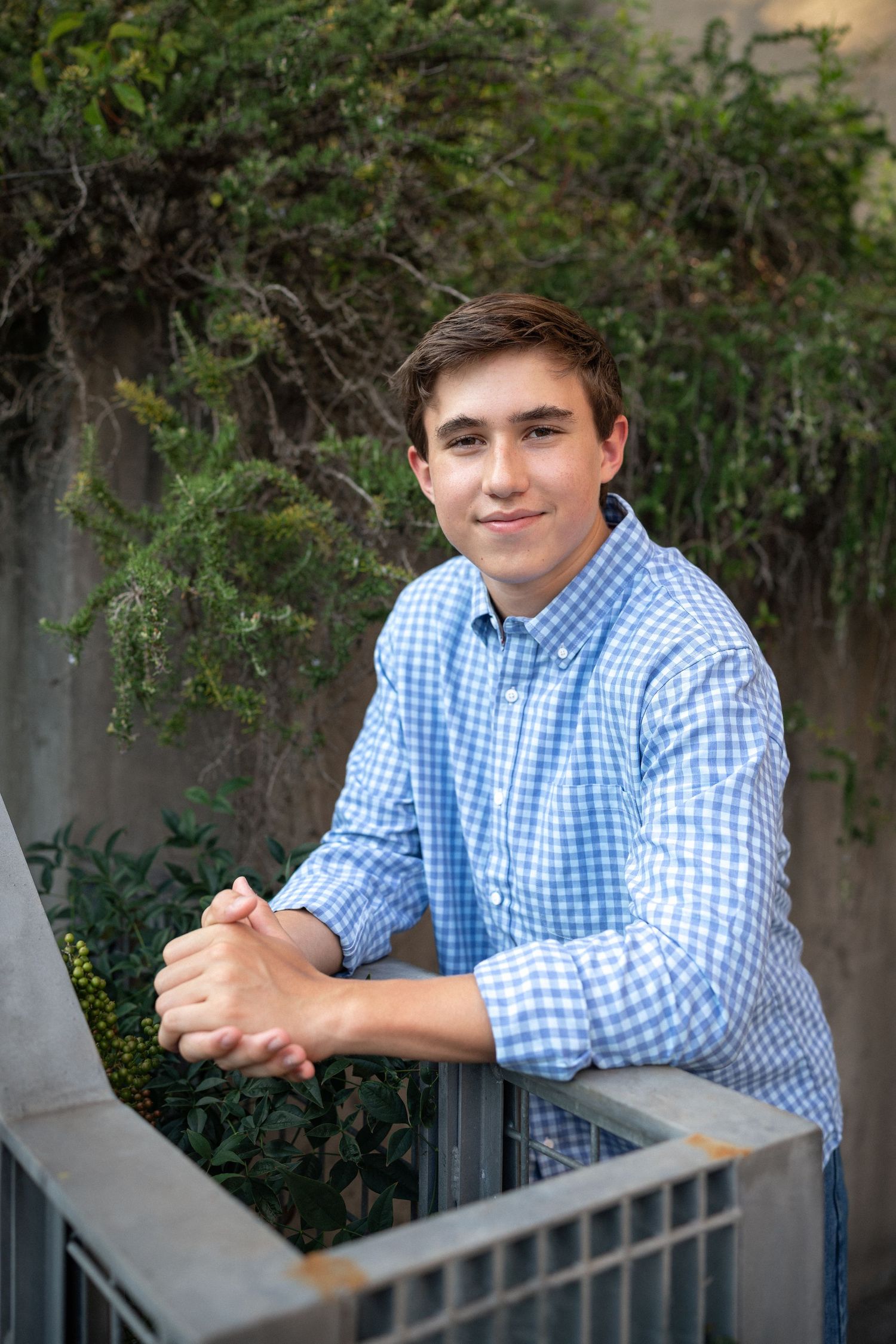 Close-up portrait smiling in a blue checkered shirt at NCMA senior session