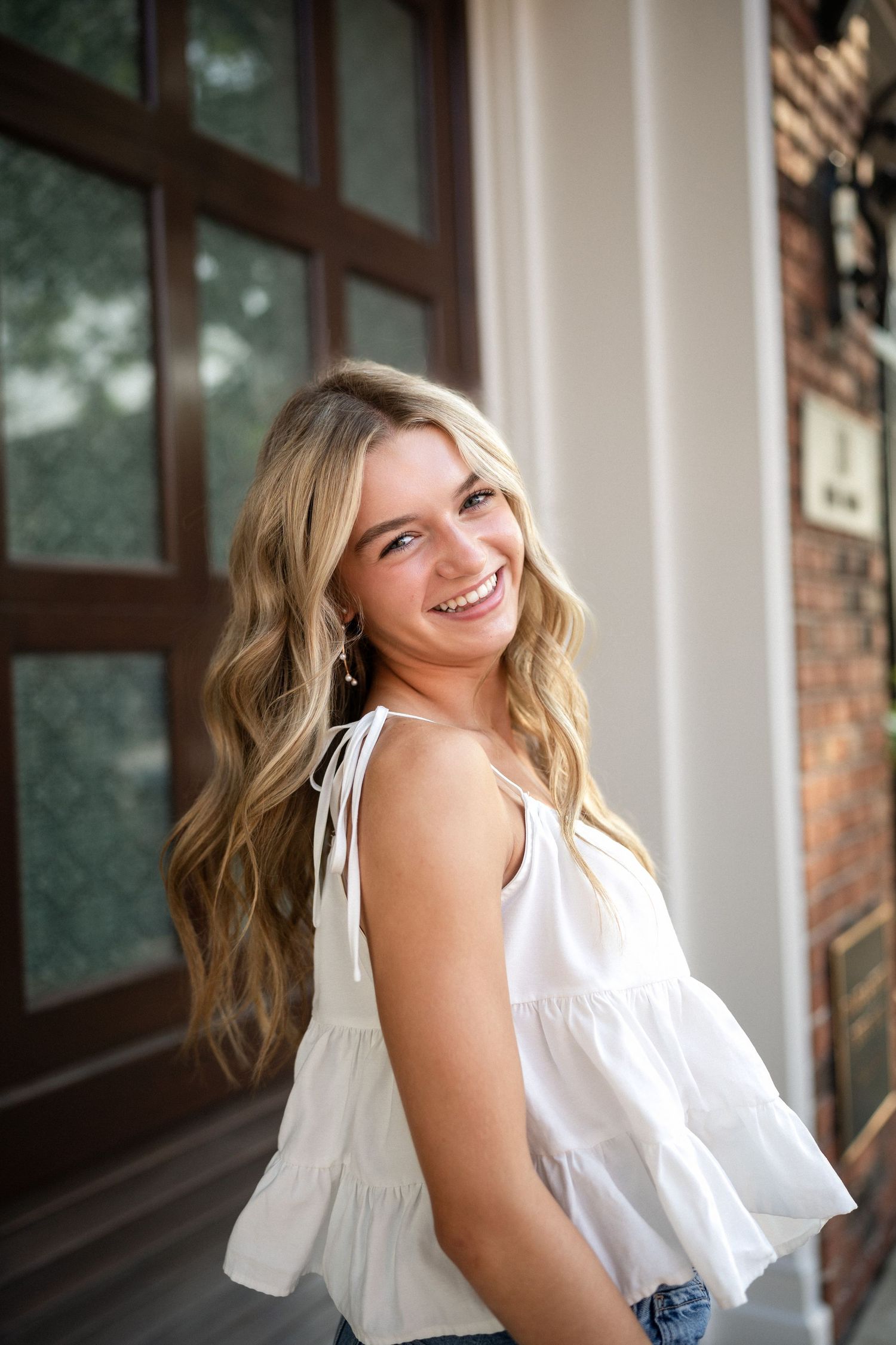 Sydney's senior portrait at a gated home entrance in downtown Wilmington, NC, featuring elegant ironwork and greenery