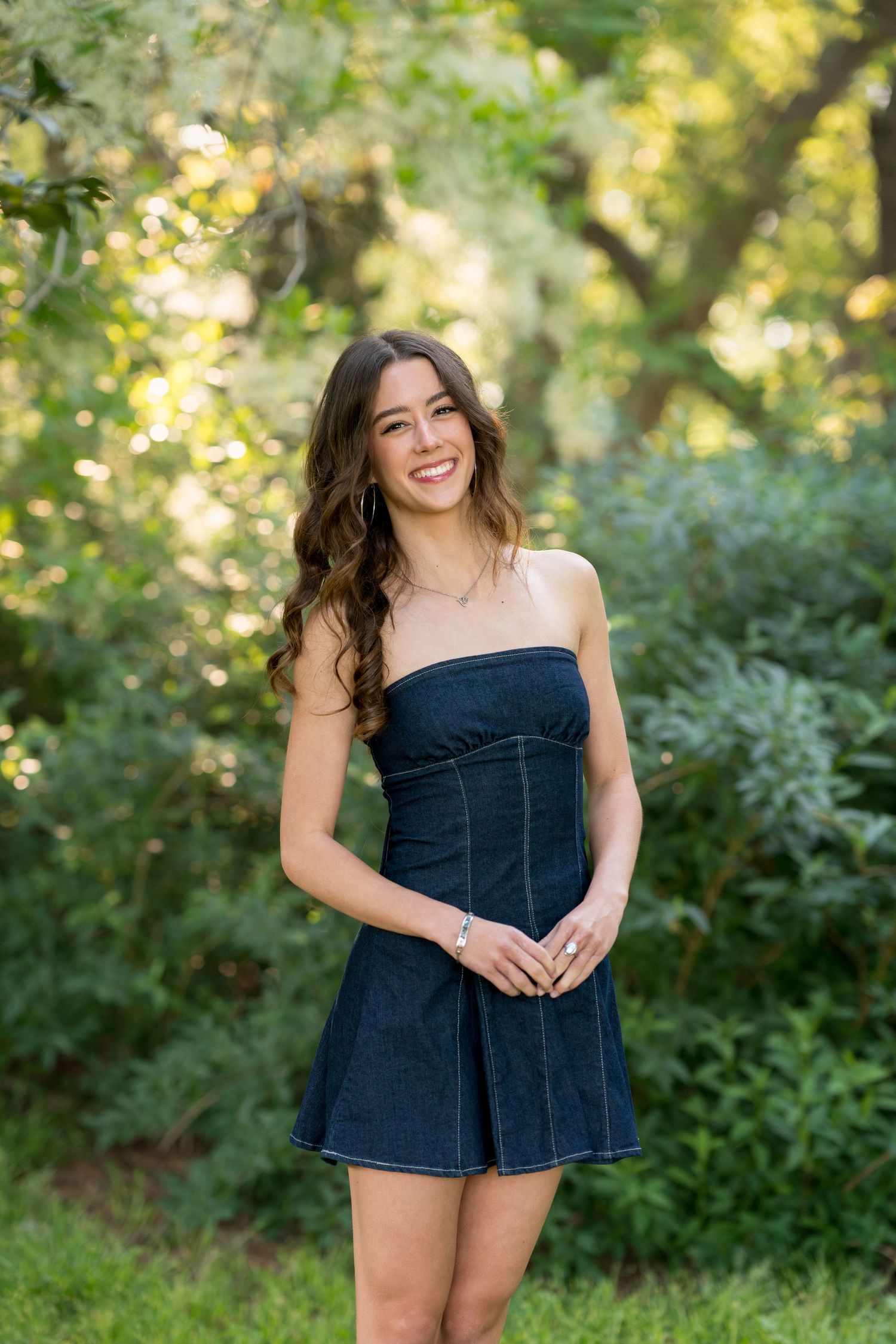 High school senior girl in a denim dress standing at Horseshoe Farm Preserve in Wake Forest, North Carolina.