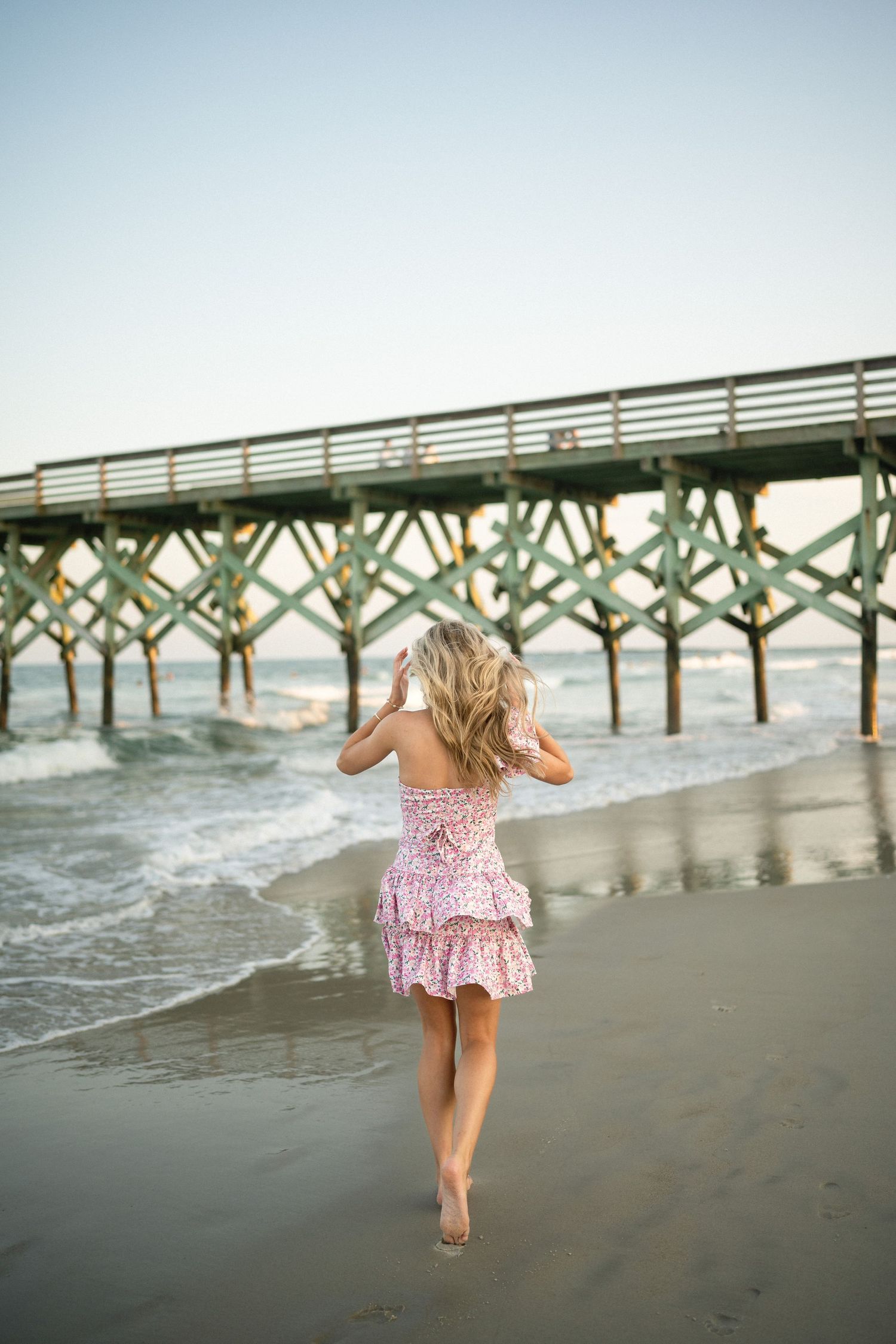 Senior portrait of Sydney at Wilmington, NC pier, showcasing a ocean backdrop during a beachside photo session