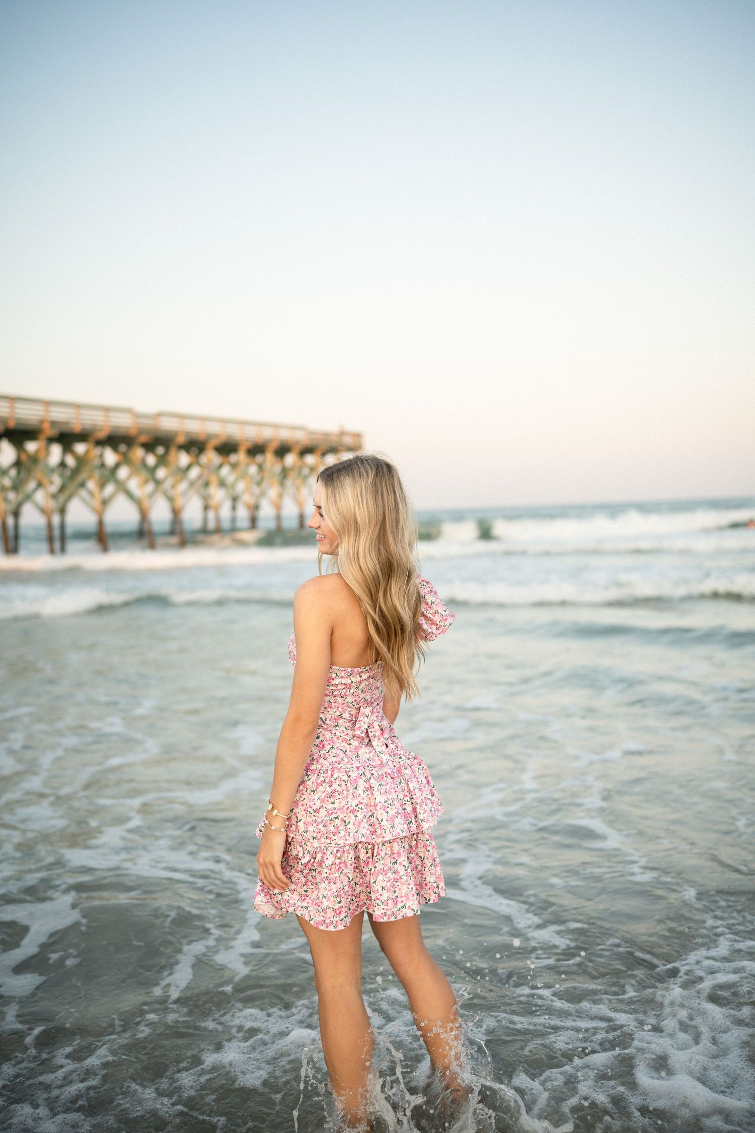 Senior portrait of Sydney at Wilmington, NC pier, showcasing a ocean backdrop during a beachside photo session