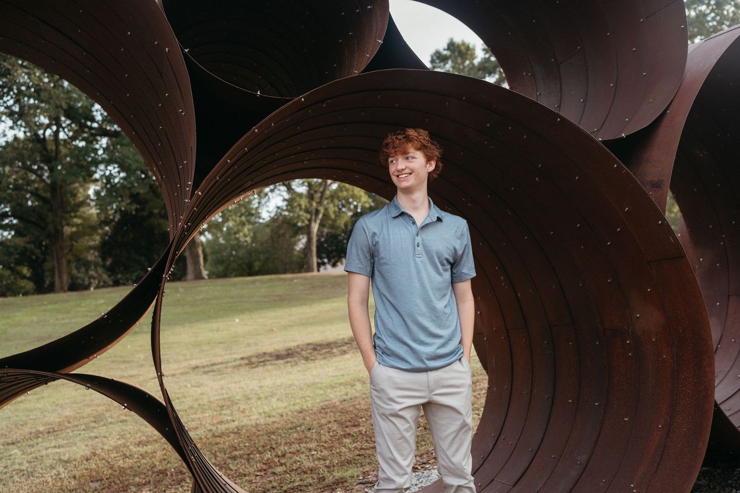 High school senior portrait at Dorothea Dix Park in Raleigh featuring blue polo and khaki pants